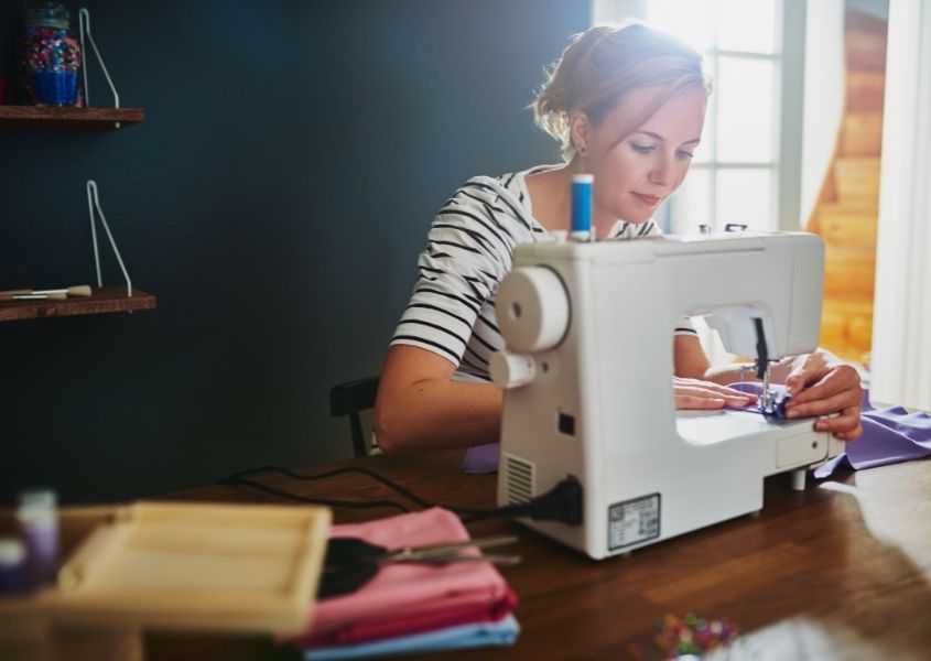 woman at sewing machine for 10 easy home refresh projects blog