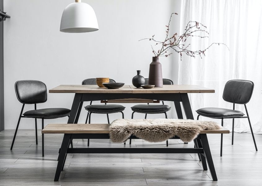 Reclaimed wood dining table with matching wooden bench and grey faux leather dining chairs