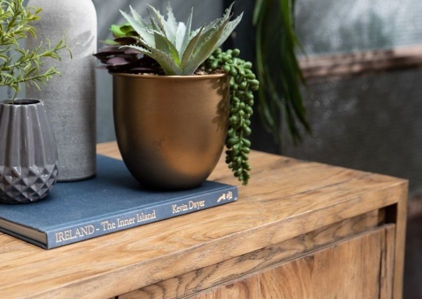 close up of reclaimed wood sideboard with bronze plant pot