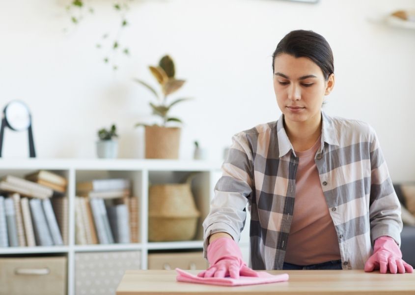 women wearing gloves cleaning wooden furniture
