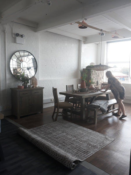 Our stylist adding the finishing touches to our Large Farringdon Reclaimed Wood Trestle Table Dining Set before it's ready for the photoshoot.