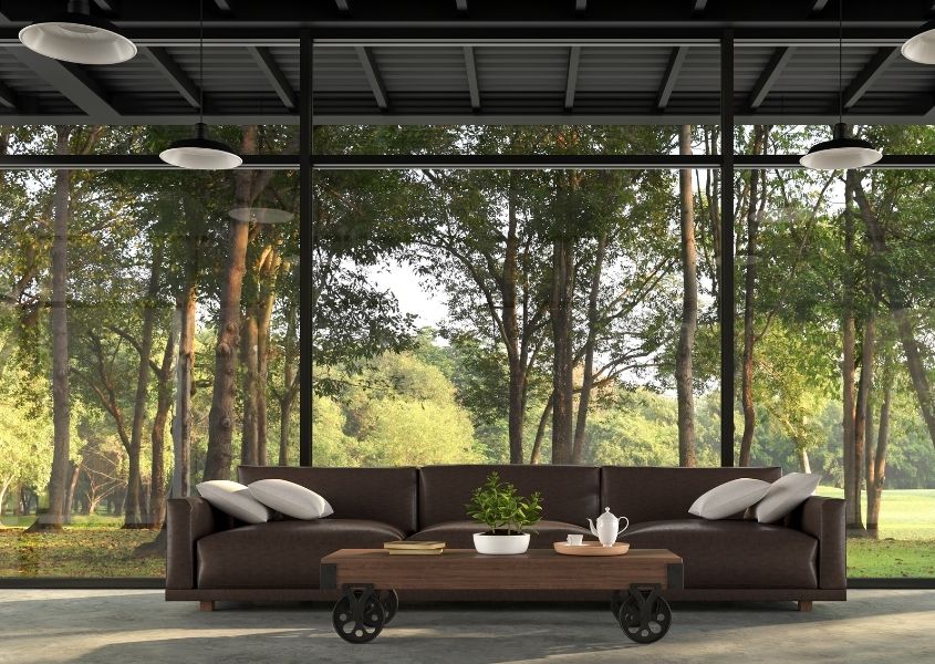 brown leather sofa next to floor to ceiling window