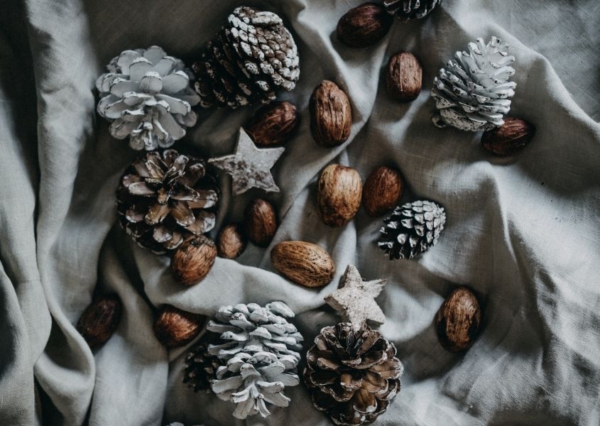 Christmas rustic pine cones and acorns on grey table cloth