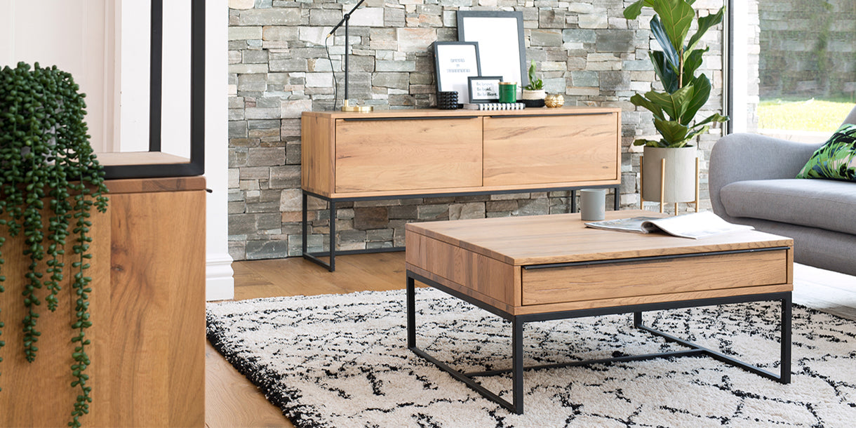 Industrial style dining room with reclaimed wood coffee table and TV unit with a zig zag rug and plants