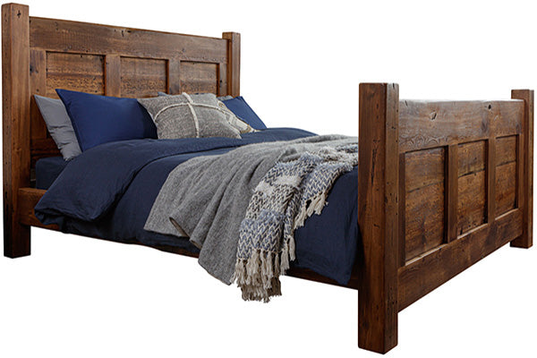 A reclaimed wood bed in a dark finish with navy blue bedsheets
