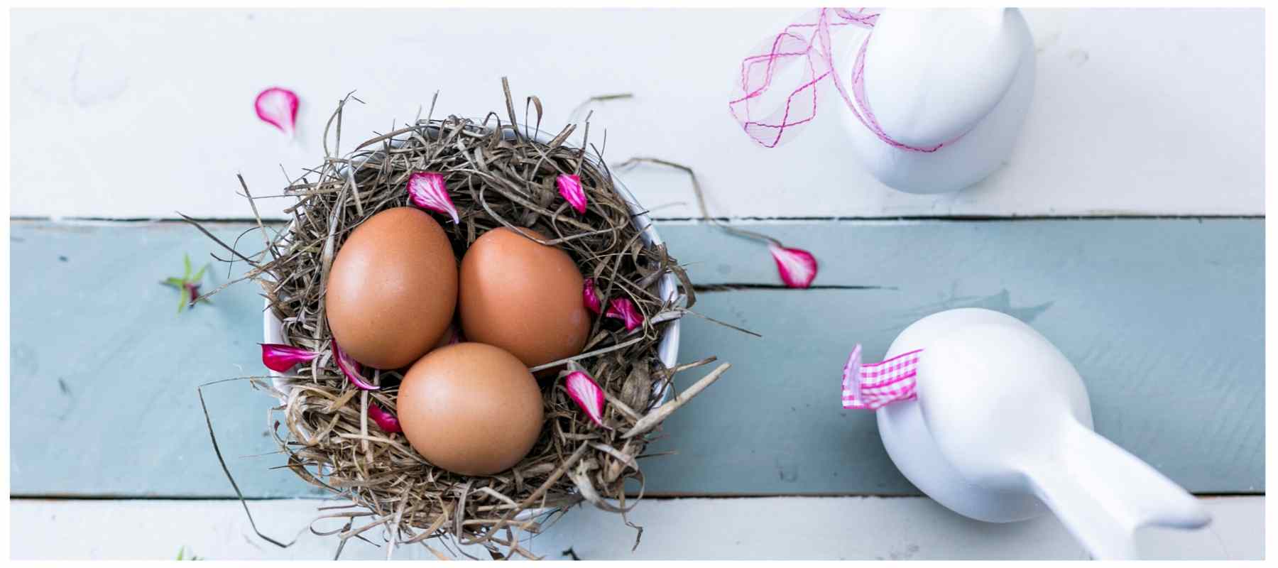 Eggs in a cup with straw and ceramic rabbits