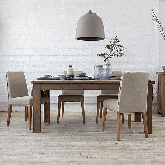 Hanging pendant light with reclaimed wood dining table and upholstered chairs