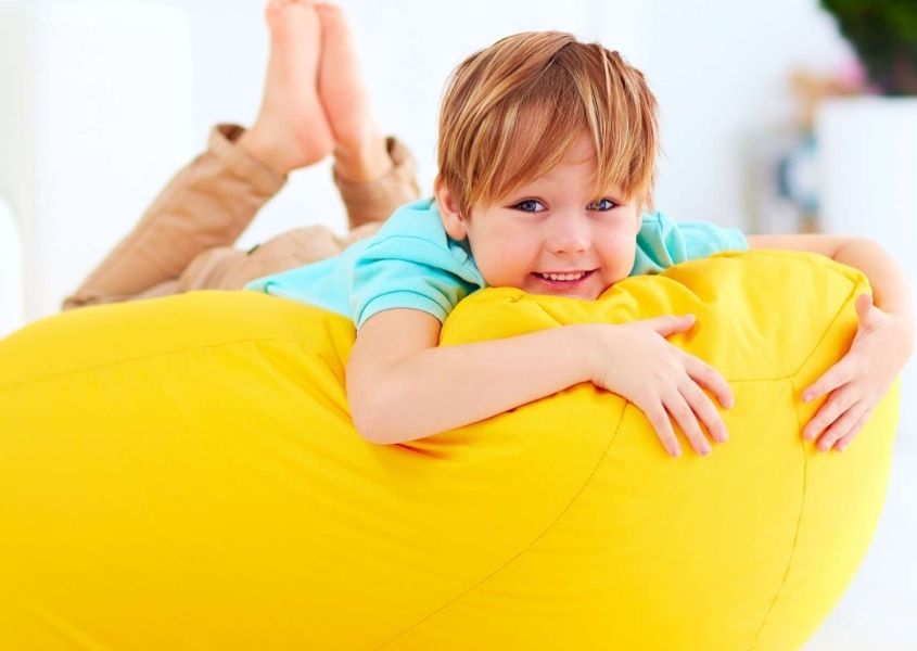 child on bright yellow bean bag
