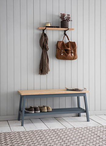 Grey hallway bench with shoes underneath