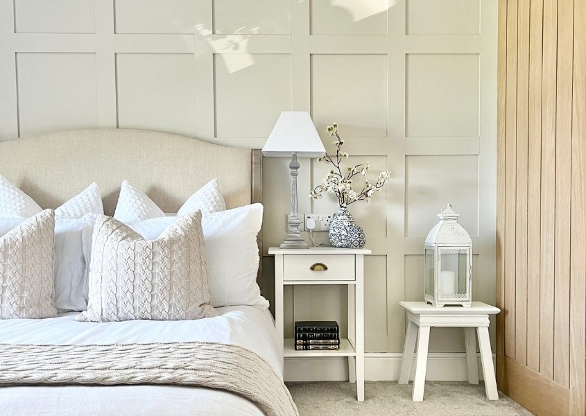 light green painted panelled wall with white bedroom side table