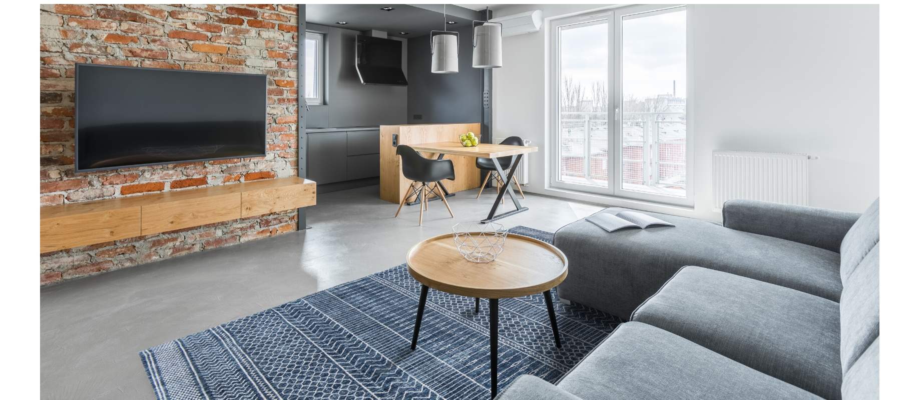 Living room with blue rug and grey sofa
