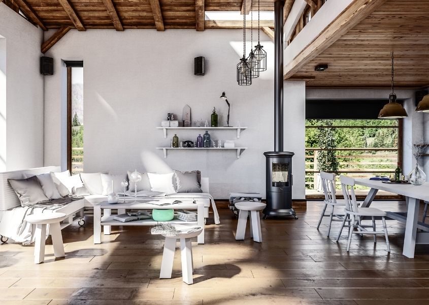 Rustic open plan living room with high ceiling and large wood burner