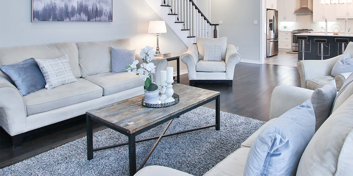 An industrial coffee table with a wooden top in a bright living room with beige sofas