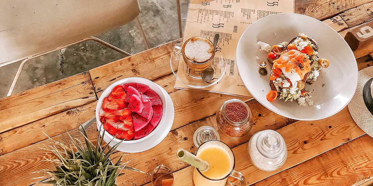 A reclaimed wooden coffee table with bowls of food and a plant