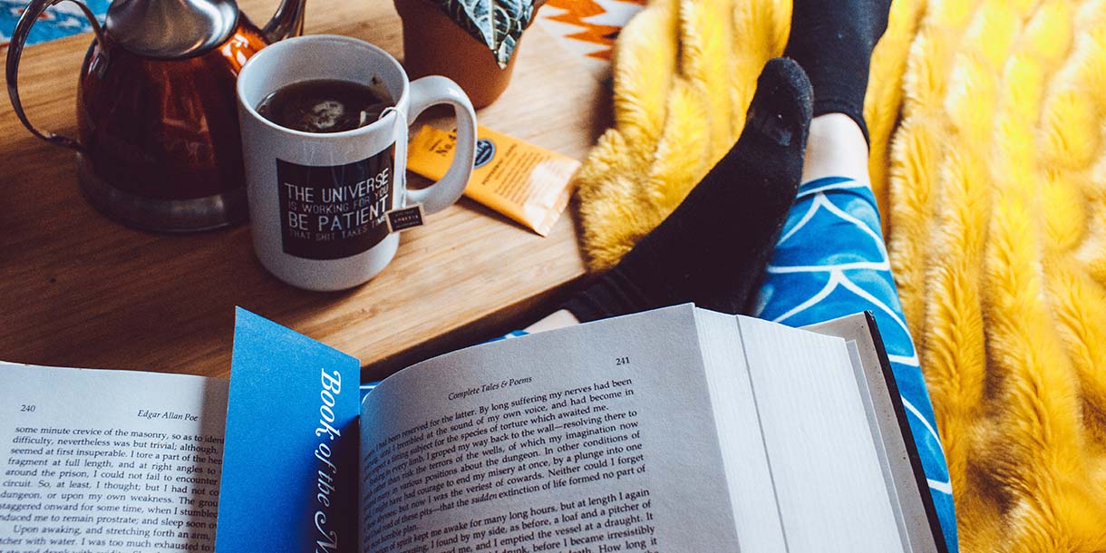 Person reading book in bed