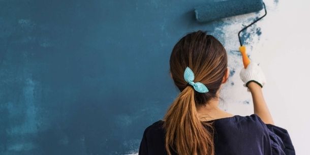 Woman painting wall for quick ways to transform a room over the weekend blog