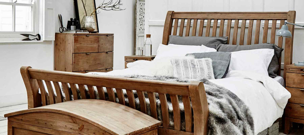 Reclaimed wood bed frame with grey faux fur throw