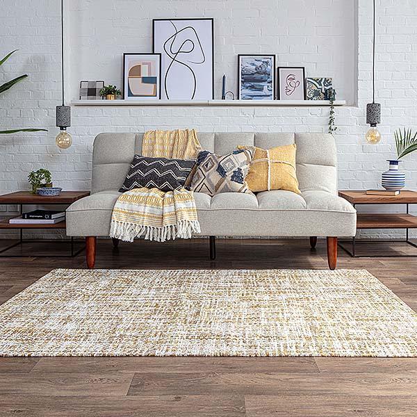 Padded fabric sofa with yellow throw and cushions