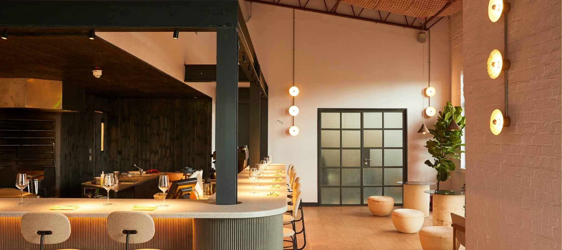 Silo London bar area featuring cream stools and black metal support beams and door