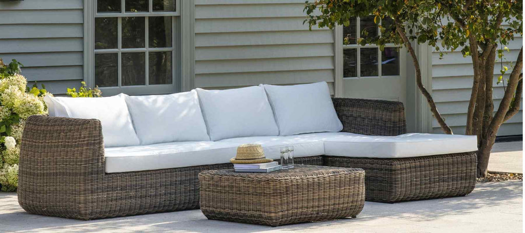 Rattan garden sofa set next to a tree