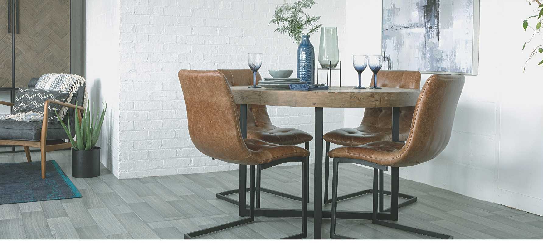 Round reclaimed  wood dining table with brown leather chairs