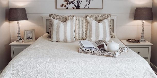 small bedroom with white painted bed and matching bed tables