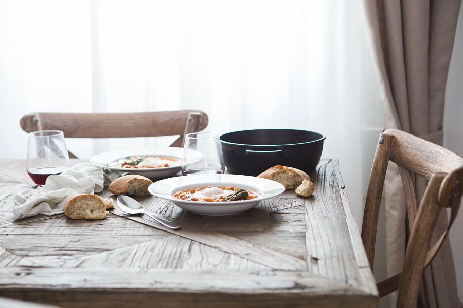 Rustic dining table and chairs with white soup bowl