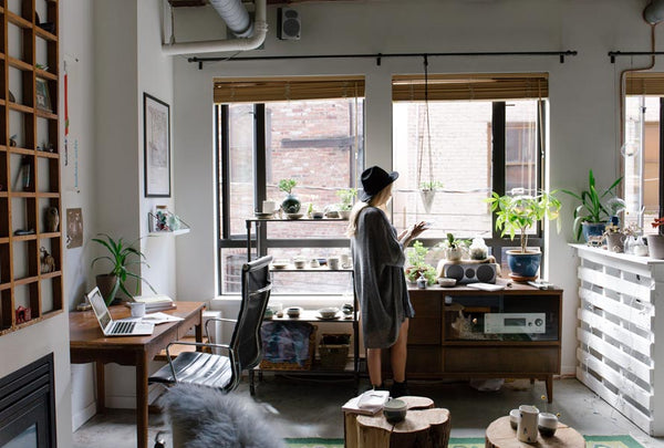 Woman in Bedroom with Desk and Chest of Drawers