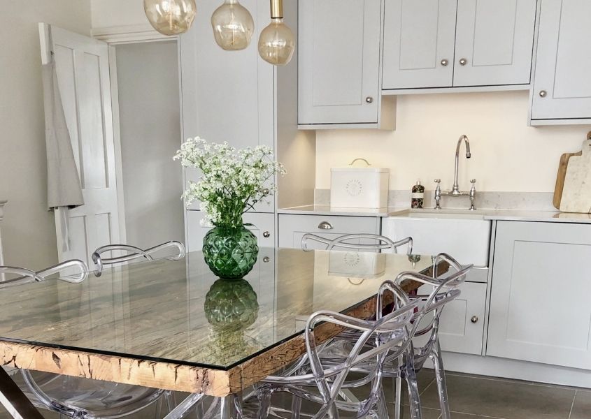 Reclaimed wood dining table with glass top in white kitchen