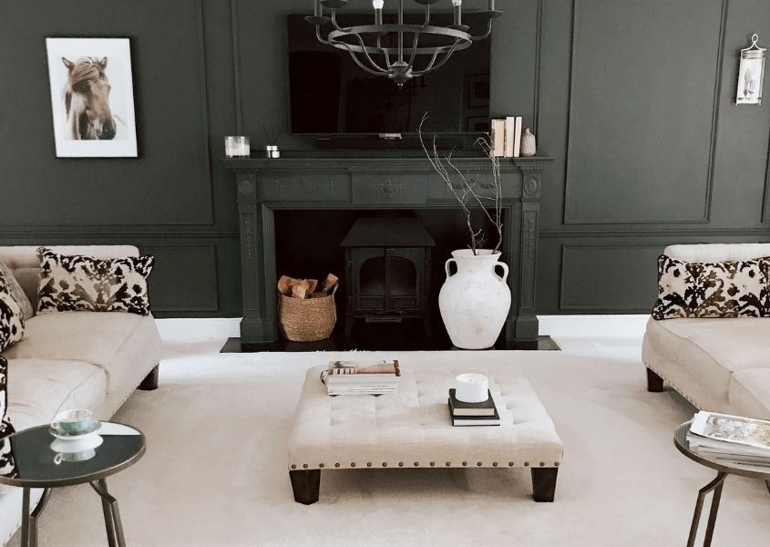 Living room with dark grey feature wall and fireplace and white carpet and sofas
