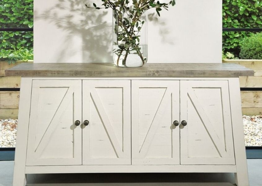 White reclaimed wood sideboard with tall glass vase and green stems