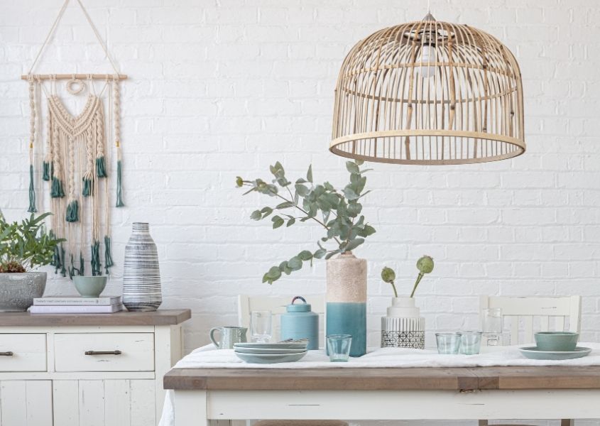 Bamboo hanging pendant light over white reclaimed wood dining table with vase and white table runner