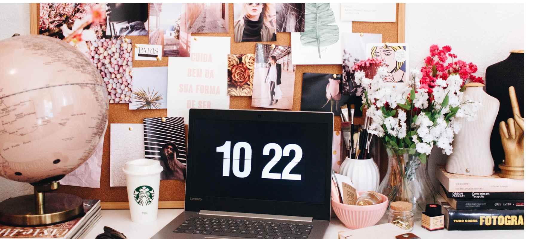 Untidy desk with black clock and Starbucks coffee cup