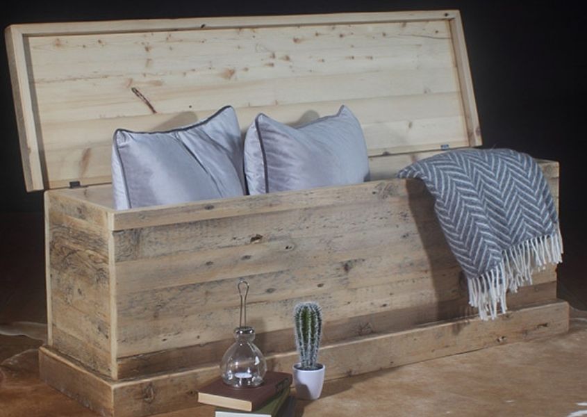 Reclaimed wood blanket box with lid open and light blue cushion and blankets visible.