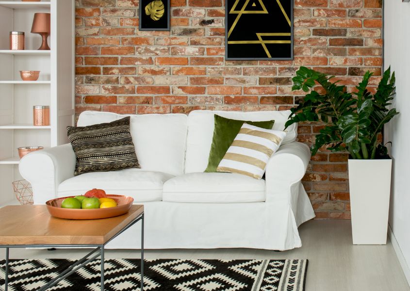 small living room with white sofa and exposed brick wall