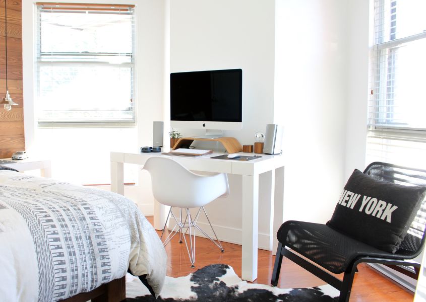 small white desk in bedroom next to two windows