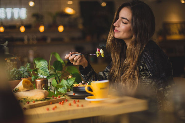 Woman eating at wooden table