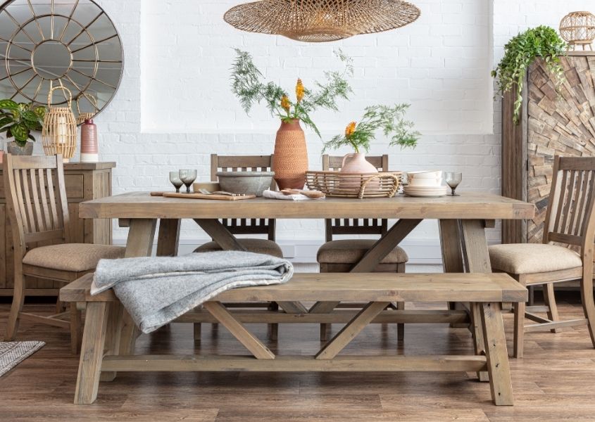 Reclaimed wood dining set including trestle table, wooden bench and wooden dining chairs with terracotta vase on table