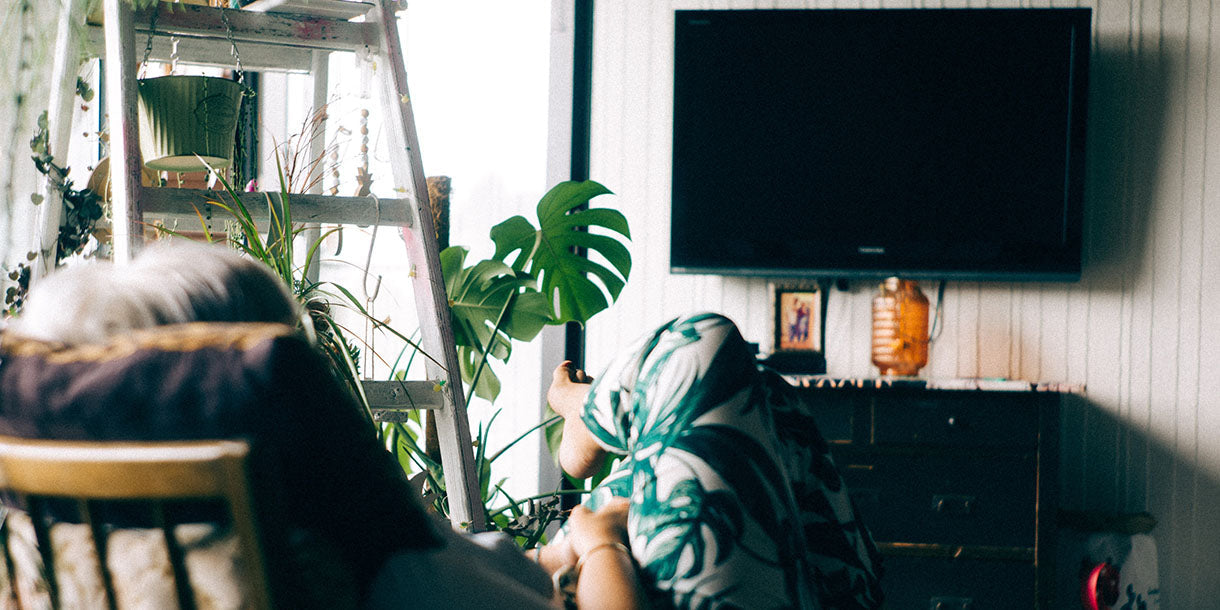 Person sitting in an arm chair in front of a TV