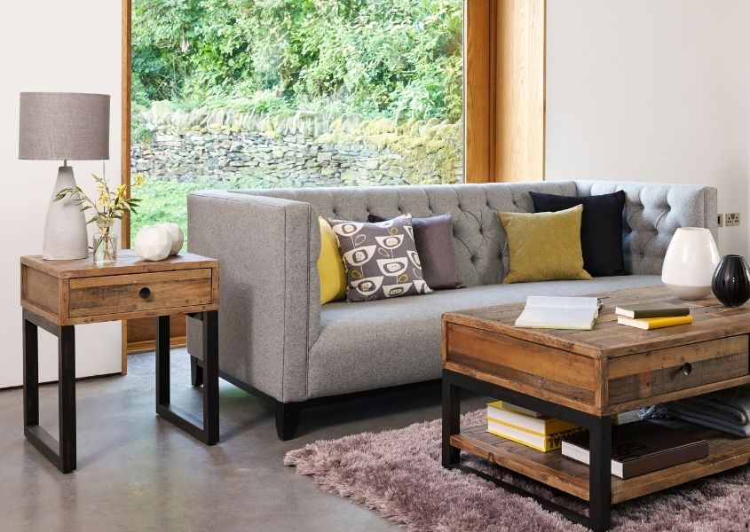 Industrial coffee table and side table with black metal legs next to grey fabric sofa