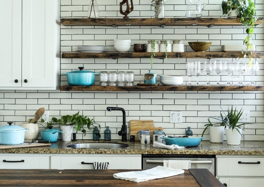 White kitchen with rustic wooden shelves and wooden table