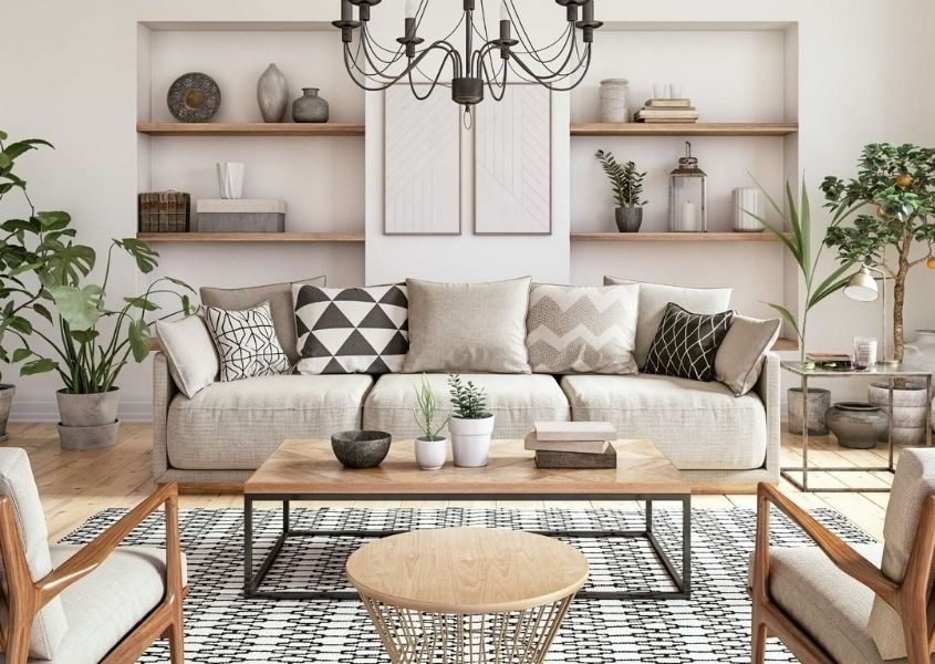 Bright living room with large cream sofa, two armchairs, industrial coffee table and two big green house plants