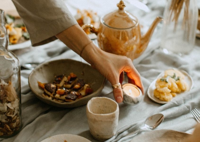 Hand putting candle on a wooden dining table