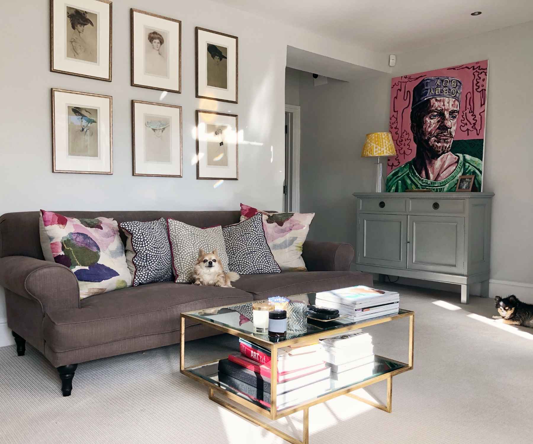 Grey sofa with glass coffee table and bright wall art