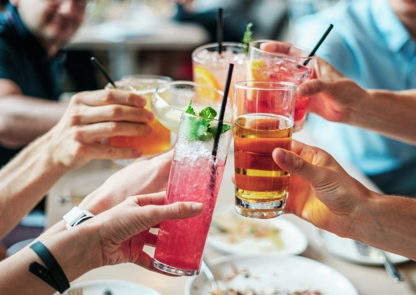 People at an outdoor dining table with cold drinks