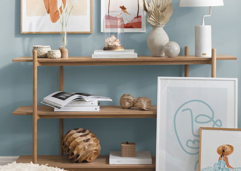 wooden bookcase with ornaments and prints