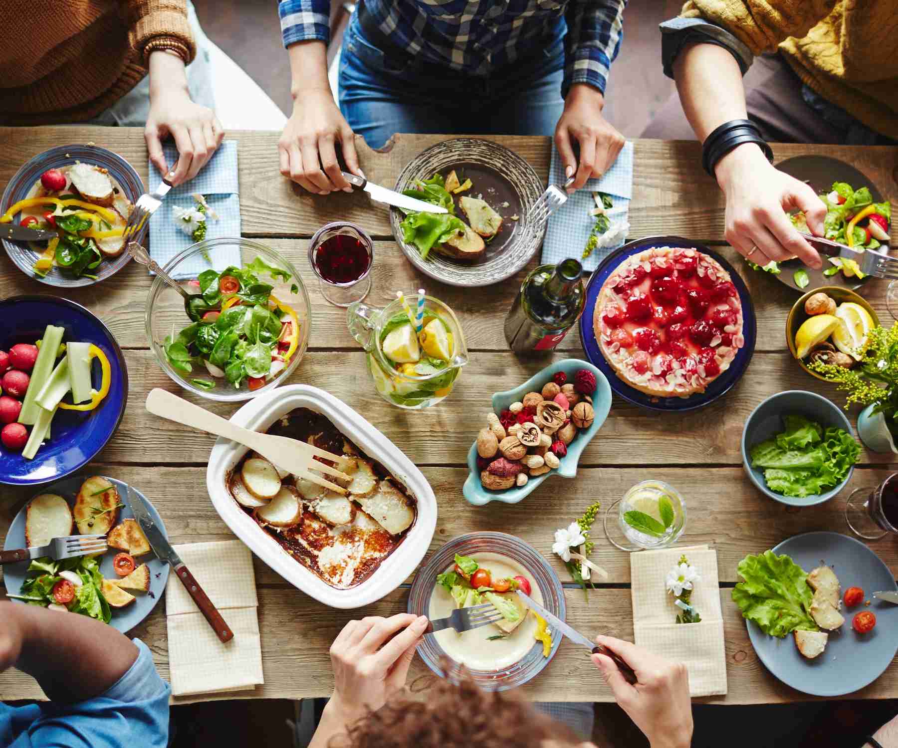 Group of people eating around a wood dining table