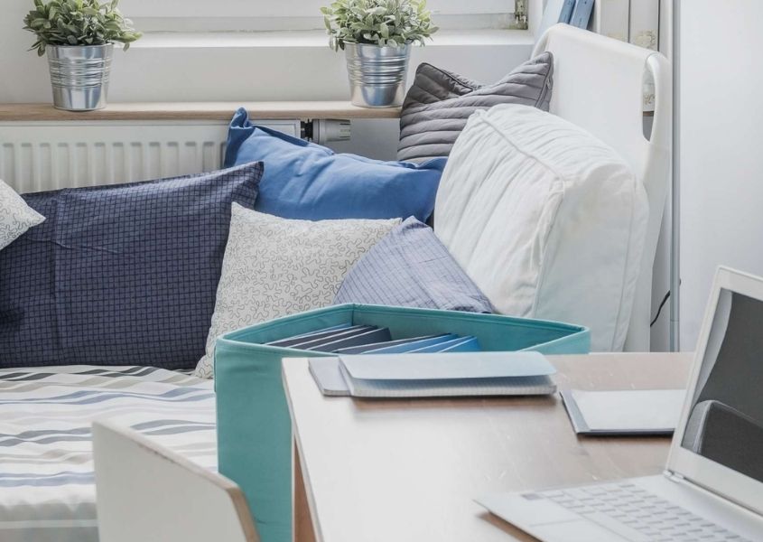 white day bed with blue cushions and throws