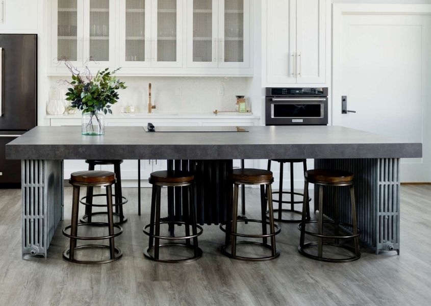 Dark grey stone kitchen island with industrial bar stools