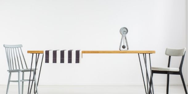 Minimalist dining room with wood dining table with black steel legs and wooden chairs